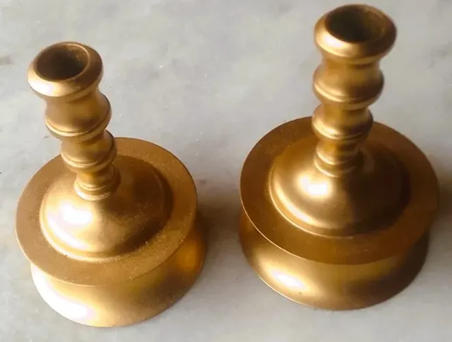 Par de antigos castiçais bojudos em metal dourado torneado.