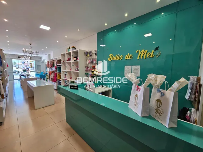 Loja de roupa infantojuvenil completa com estoque e mobília na avenida principal