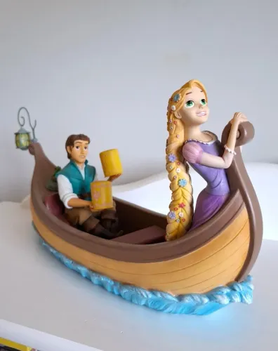 estátua rapunzel e flynn rider no barco disney enesco