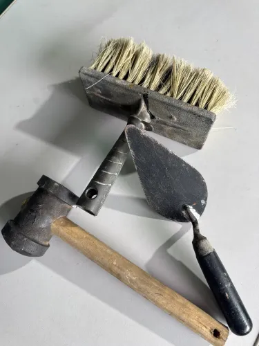 Martelo de borracha, colher de pedreiro pequena e broxa