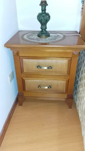 Conjunto de quarto com cama e duas mesas de cabeceira.