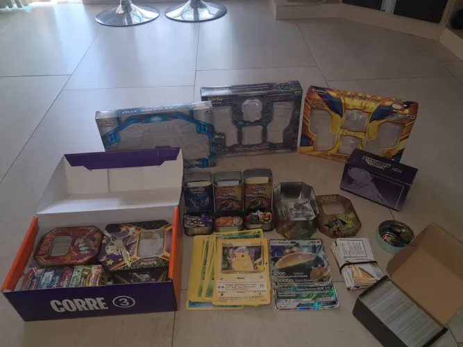 Muitas cartas de pokemon normais,energias,treinadores,bonecos,box,latas,moedas.
