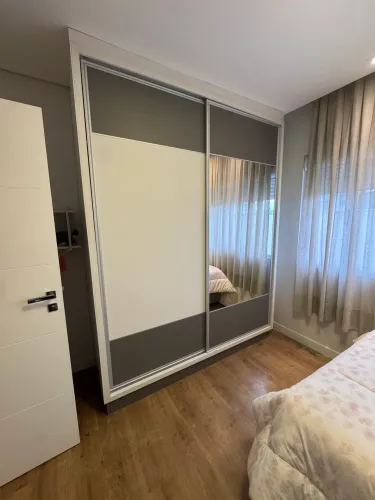 Quarto aguarda roupa escrivaninha e armário aéreo