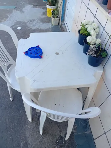 Vendo uma mesa e duas cadeiras brancas.