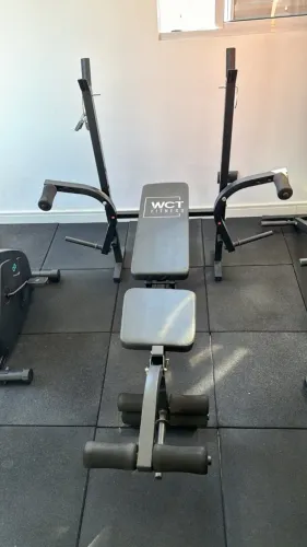 Banco de supino ajustável WCT Fitness preto com suporte para barra e módulo de pernas