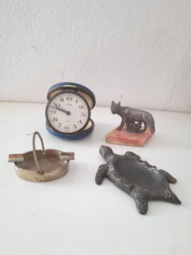 Lote peças antigas um relógio a corda dois cinzeiros uma estátua de metal.
