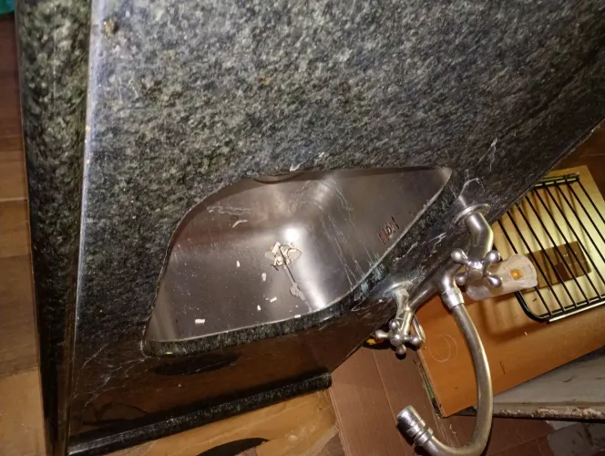 Pia de granito com cuba inox e torneiras.