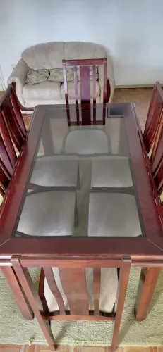 Mesa de jantar de madeira maciça, laqueada com tampo de vidro e seis cadeiras estofadas.