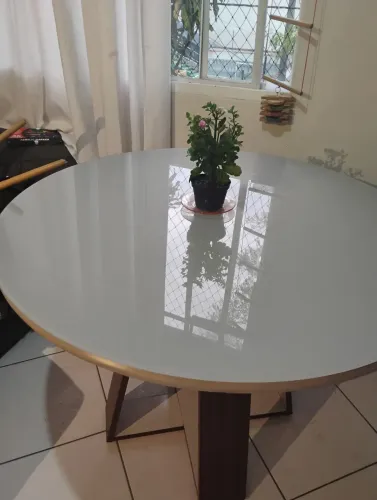Mesa redonda de jantar com pés de madeira e tampo de vidro