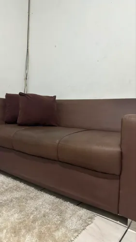 Sofá usado em boas condições com marcas de uso.