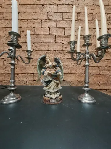 Linda estatueta em resina de: Tereza Collectiom e dois castiçais em aço importado.