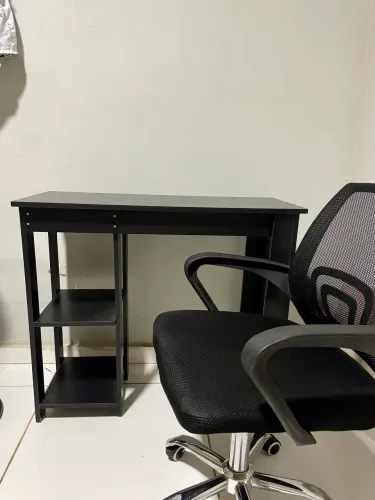 Mesa de estudos com cadeira de escritório giratória.