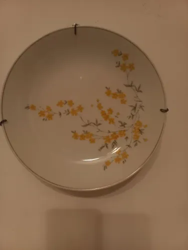 Prato pintado com flores amarelas com suporte prá pendurar na parede,diâmetro de 20 cm.