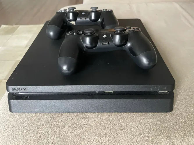 Ps4 slim acompanhado de dois controles