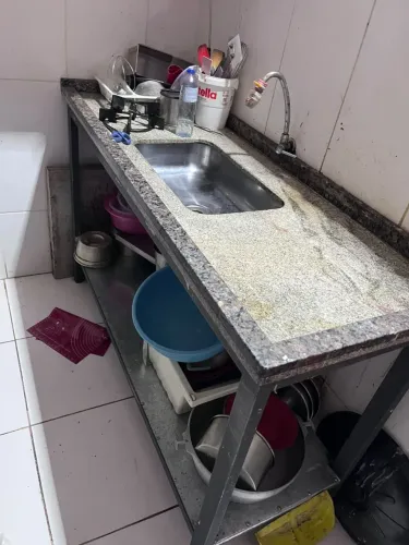 Pia móvel de pedra com base feita sob medida e com aparador de panelas embaixo.