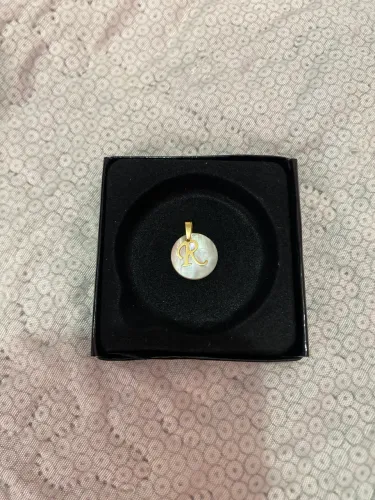 Pingente em madre pérola e ouro.