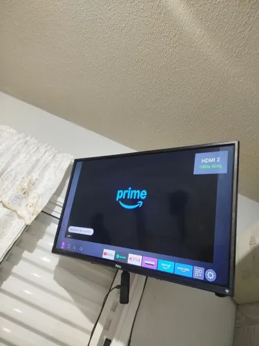 Televisão 32p com Fire Tv Stick 4k, com Alexa integrada, e suporte articulado para parede.