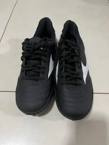 Chuteira Mizuno Morelia Club AS preta e branca com travas para grama sintética.