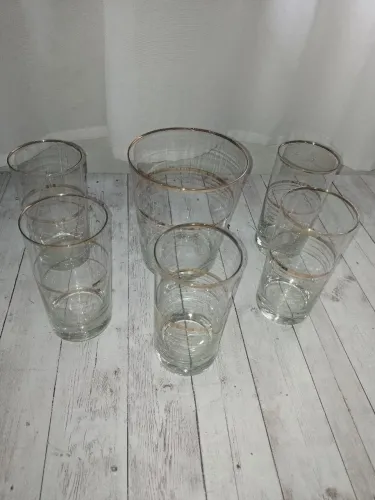 Antigo jogo com 5 copos e balde de gelo com frisos dourados.