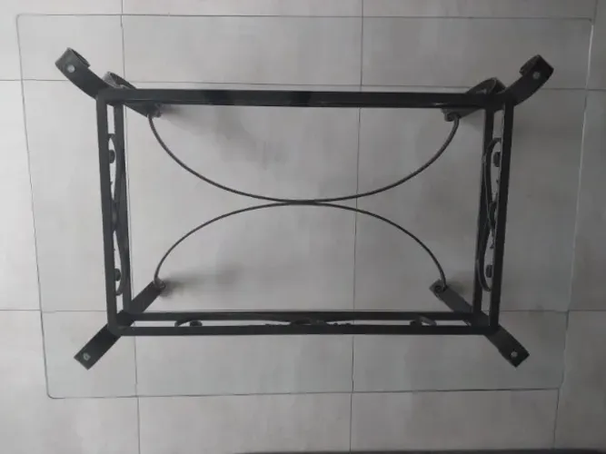 Mesa de centro com tampo de vidro e base de ferro trabalhado