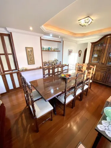 Mesa de jantar com 10 cadeiras e cristaleira com buffet.