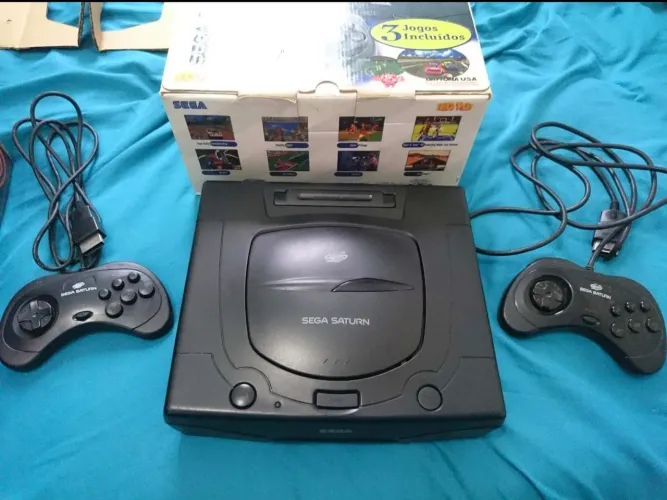 Sega Saturn na caixa com vários jogos