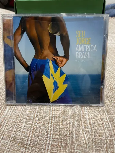 CD Seu Jorge - América Brasil, O Disco - Hits Trabalhador e Burguesinha - Ótimo Estado