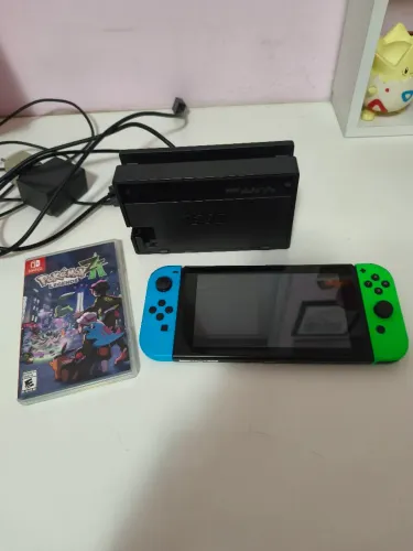 Nintendo Switch OLED vermelho e verde com jogo do pokémon Legenda AZ