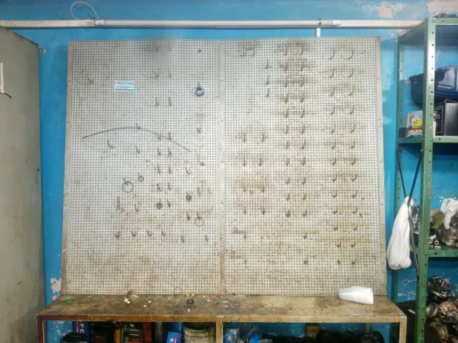 conjunto de bancada de ferro industrial com painel perfurado (pegboard) para ferramentas,