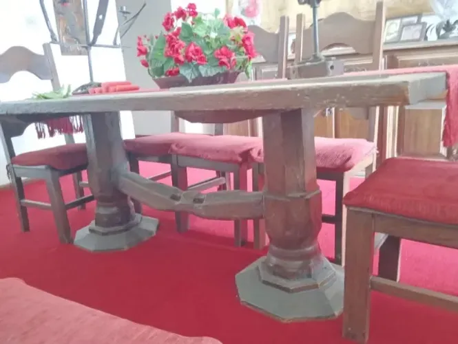 Mesa de madeira maciça, bastante robusta, com pés/pedestais torneados e acabamento escuro.