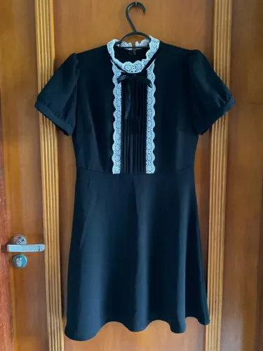 Vestido preto com detalhes em renda e gola alta