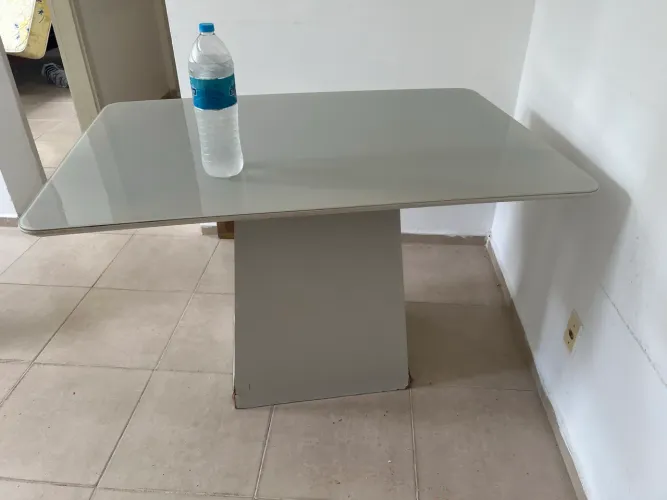 Mesa de base central com parte superior de vidro