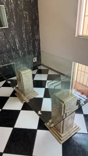 Mesa de vidro com pés de pedra.