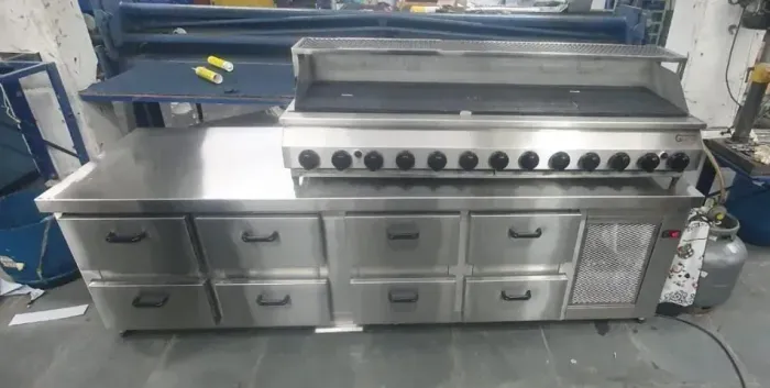 Balcão refrigerado c/ base p/ cocção, c/ fogão, fritadeira, chapa e char broiler.