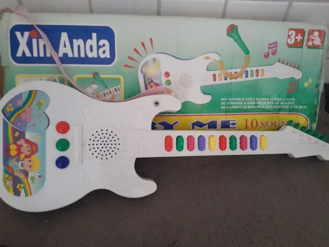 Guitarra infantil toca com pilha 