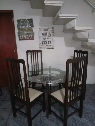 Mesa de jantar redonda, com quatro cadeiras, tampo de vidro e aparador