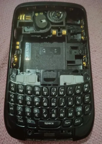 carcaça intermediária e o teclado QWERTY desmontados de um smartphone BlackBerry Curve