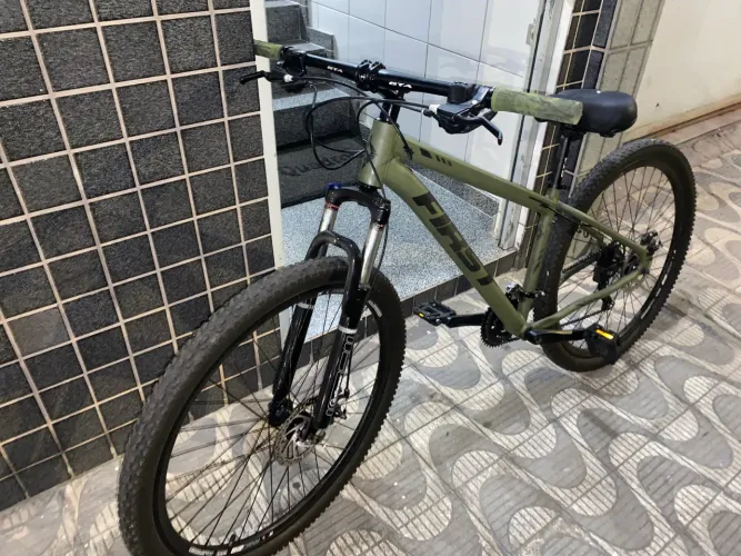 Bicicleta First ARO 29, verde militar, com cabeamento interno e quadro alumínio 6061
