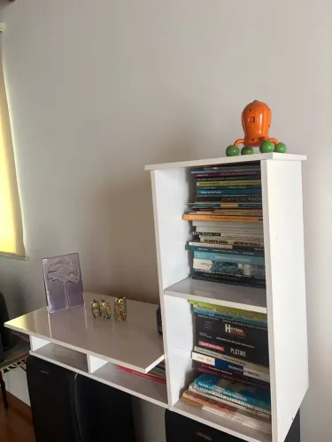 Estante branca com escrivaninha integrada e nichos