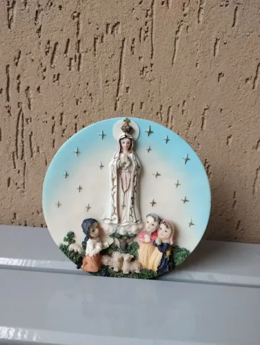 Prato decorativo de resina, em relevo, com a imagem de Nossa Sra. de Fátima e os pastore 