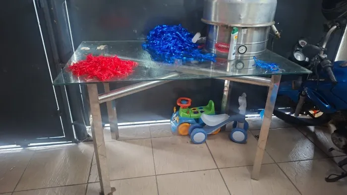 Mesa com.tampo de vidro e base de inox.