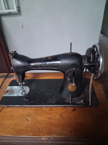 Maquina costura antiga com o gabinete