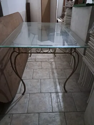 Mesa de vidro bisotado com estrutura metálica está em excelente estado