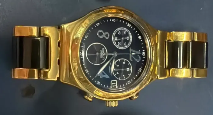 Relógio Swatch dourado.