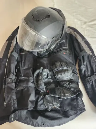 (Motociclista) Capacete, jaqueta impermeável e luvas 