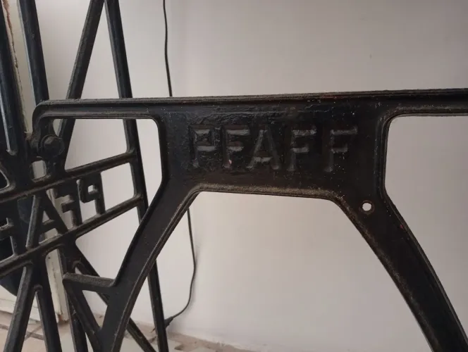 Mesa composta por tampo de granito e pés de ferro de máquina de costura