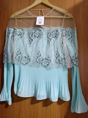 Elegante blusa azul clara destaca-se pelo delicado acabamento em renda nos ombros