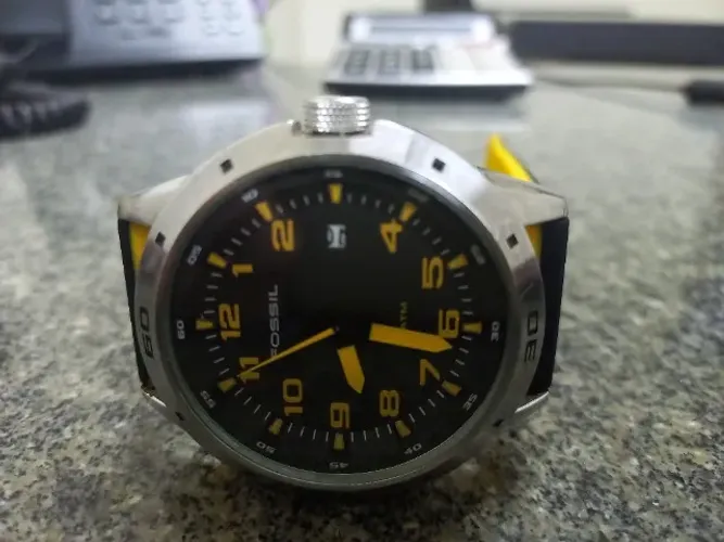 Relogio Fossil fundo preto e amarelo.