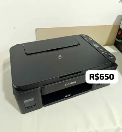 Impressora com tintas no tanque e alguns papéis 