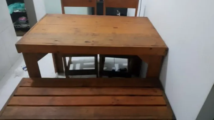 Mesa de madeira com duas cadeiras e um banco